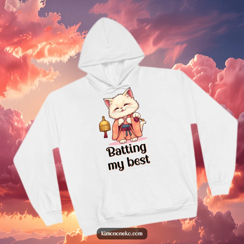 Funny hoodie showcasing a fluffy kawaii cat wearing a traditional kimono, playfully swatting at a small bell, perfect for cat lovers.