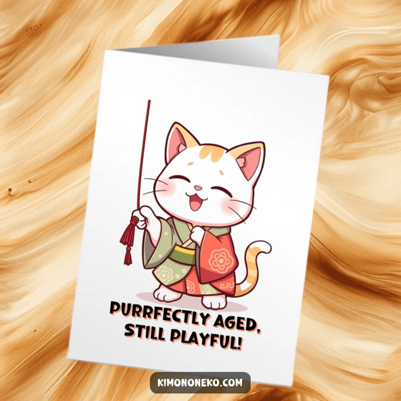 Funny Free Printable Birthday Card: Kawaii cat in vibrant kimono playfully batting at a dangling string, looking mischievous.