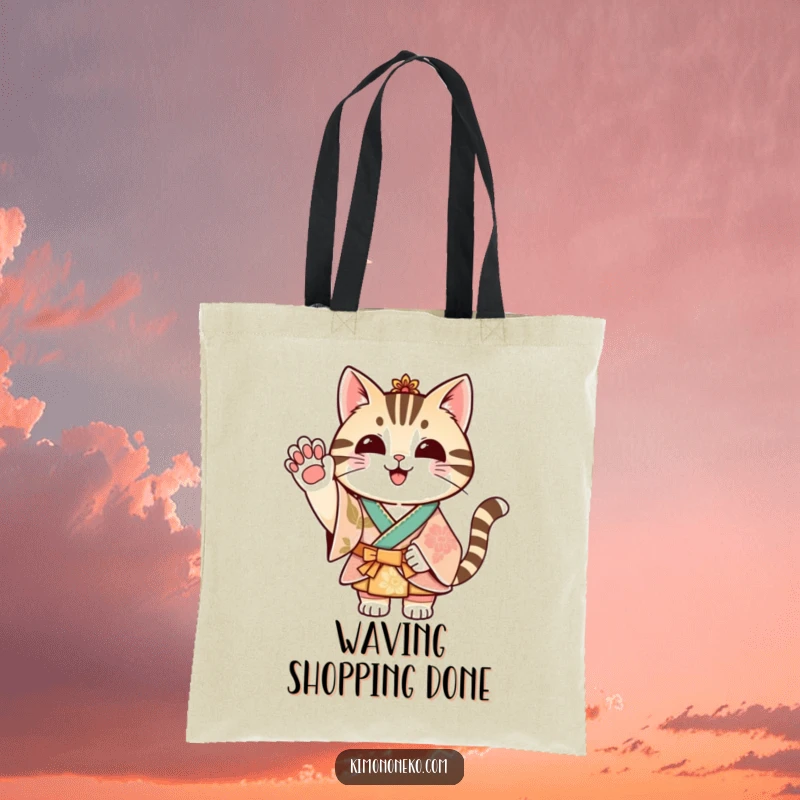 Funny striped cat in a festive kimono waving its paw, featured on a durable tote bag.
